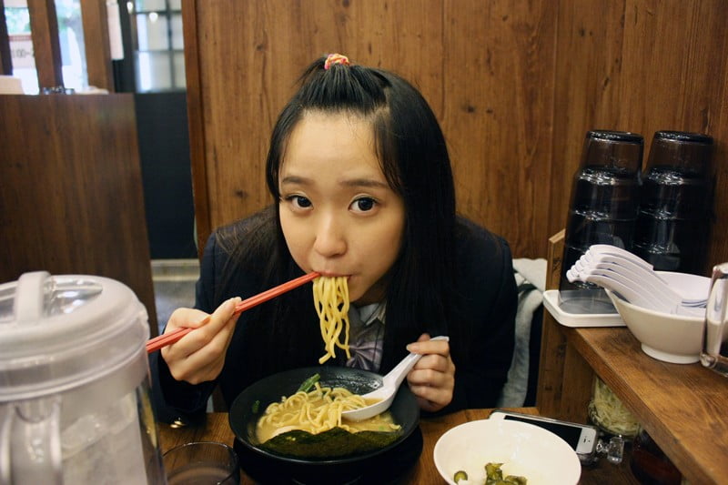 ラーメンを食べる女子校生